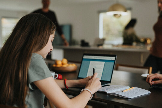 Pre-Adolescent girl using laptop while sitting at home
