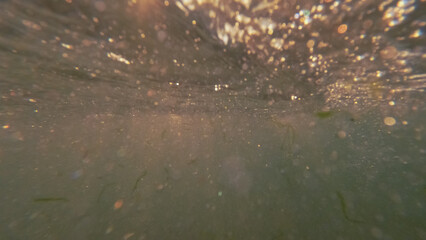Underwater surface. Sea texture. Sunlight with bubbles rising to ocean abstract marine liquid drops empty space background.