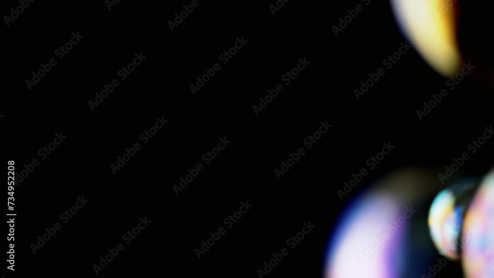 Poster lot of large colorful soap bubbles fly on a black background in empty space. blowing. foam. liquid s