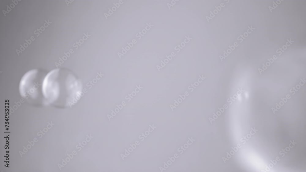 Poster group soap bubbles moving on a gray background in empty space. close up. blowing large, small transp