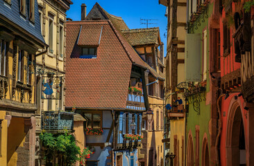 Fototapeta na wymiar Traditional colorful half timbered houses in a popular village on the Alsatian Wine Route in Riquewihr, France