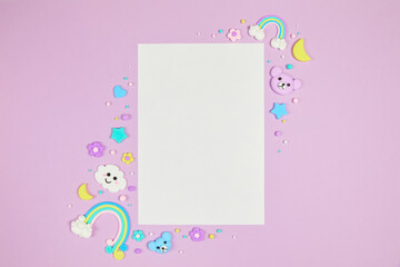 Blank white card on pastel purple background with frame of cute kawaii air plasticine handmade cartoon animals, stars, rainbows. Empty photo frames, baby's photo book, scrapbooking design template