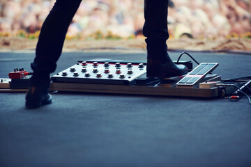 Artist, stage and feet on equipment of instrument at concert, music festival or live event in...