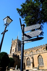 View of All Saints church along Church Street with a signpost and lamppost in the foreground, Martock, Somerset, UK, Europe.