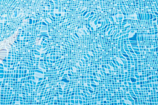 Rippling water surface in a bright blue tiled pool