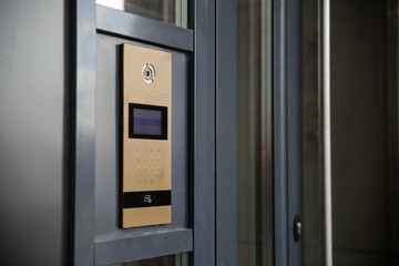 Modern entrance doorbell intercom in apartment building, with a video surveillance camera