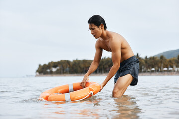 Alert Asian Lifeguard Ensuring Safety on Sunny Beach