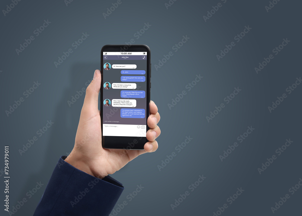Poster man texting with friend using messaging application on smartphone against grey background, closeup. 