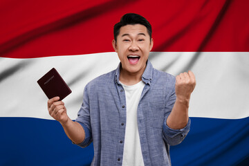 Immigration. Happy man with passport against national flag of Netherlands