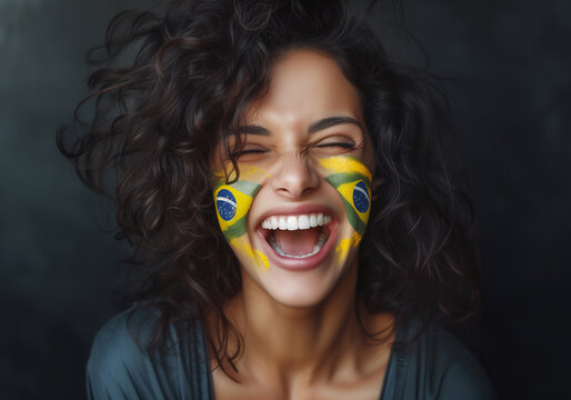 Beautiful girl as Euphoric National BRAZIL Team Fan with painted country flag colors face excited laughing and screaming straight at the camera. Active sports fans movement and human emotions.