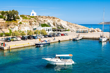 Fototapeta na wymiar View of Kimolos port with white church and sea bay, Kimolos island, Cyclades, Greece