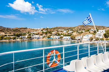 Deck of ferry with Greek flag leaving Milos island and sailing to Kimolos island, Cyclades, Greece
