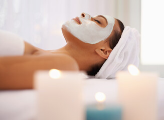 Woman, face mask and candles for wellness in spa, detox and facial treatment with cosmetic product....