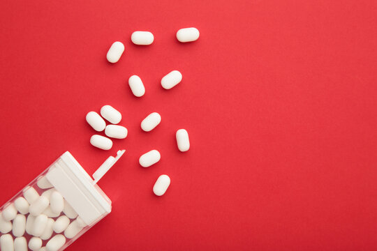 Tasty mint dragee candies with box on red background. Space for text