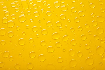 Water drops on yellow background. Space for text