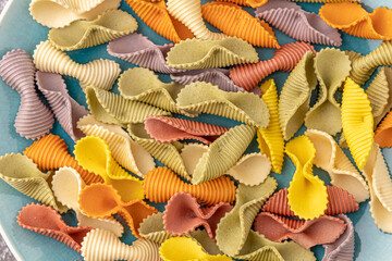 Colorful pasta background. Top view of five colors pasta shells .Heap of colorful spiral...