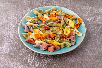 Colorful pasta background. Top view of five colors pasta shells .Heap of colorful spiral pasta,macaroni texture.