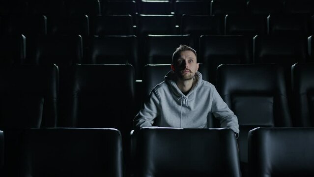 A man in a movie theater. The viewer is alone in the cinema. An interesting blockbuster premiere