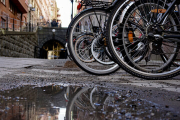 A puddle of water by parked bikes