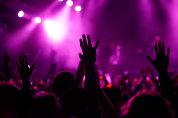 Hands, crowd and silhouette at music festival with dancing for rock party at concert with stage lights, nightclub or dj. People, dance floor and holiday event in summer for entertainment, dark or fun