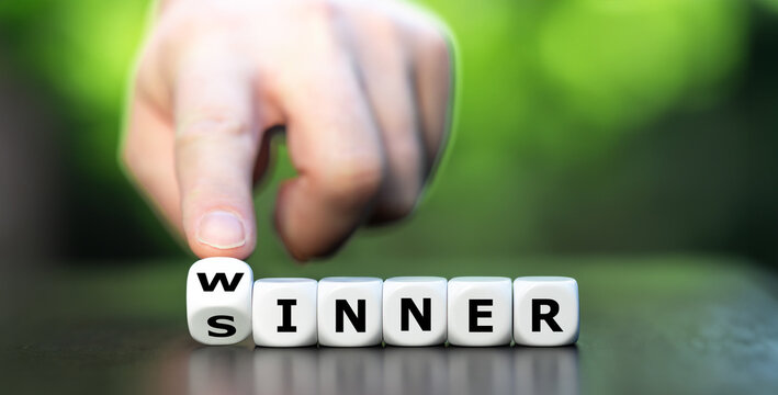 Hand turns dice and changes the word sinner to winner. Symbol for stop being a sinner and become a winner.