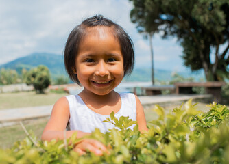 retrato de niña indigena sonriendo y mirando la cámara