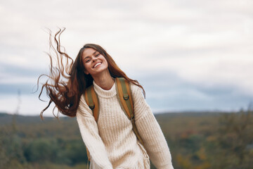 Mountain Adventure: Smiling Woman on Cliff with Backpack