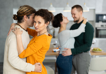 Fototapeta premium Friends dancing. Cheerful young people dancing and drinking while enjoying home party on the room