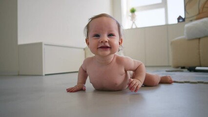 Infant in a cozy indoor setting, exploring the environment on all fours with a beaming smile and twinkling eyes, hinting at early stages of child development and curiosity.