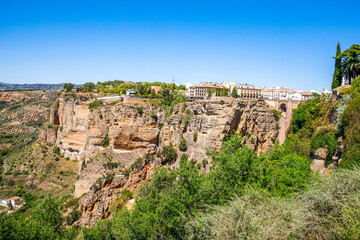 Fototapeta na wymiar Ronda, Spain. Aerial evening view of New Bridge over Guadalevin River in Ronda, Andalusia, Spain. View of the touristic city.