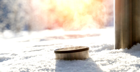 thermos with hot tea or drink in the snow