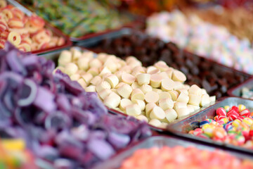 A lot of colors gummy, jelly, toffee, fudge, caramel and chocolate candies are selling in shop. Assortment of multicolored sweets as a food background. Colorful texture.