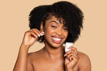 Happy african american woman flossing her teeth with bright smile