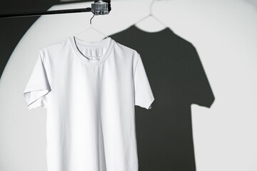 Blank T-shirt hanging in a spotlight in studio