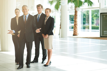 Leader, portrait and business people in a lobby, collaboration and smile with property management and cooperation. Group, manager or employees with teamwork or partnership with real estate agency