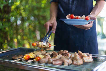 The chef is grilling delicious barbecue meat on the grill.