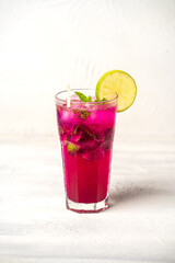 Coctel de Mojito de pitahaya decorado con una rodaja de limón en un fondo blanco