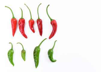 Red and green hot peppers arranged in line. Many red and green hot chili peppers on white background. Small short red hot peppers