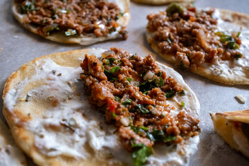 Rolling out taco dough and filling it with foods such as chicken, meat and fish on the gray table	