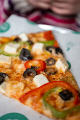 child holding a pizza