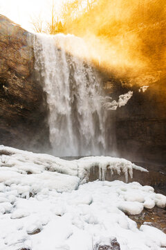 Lula Falls surrounded by icy rock in winter with golden sunlight pouring over the top, Lookout Mountain, Georgia