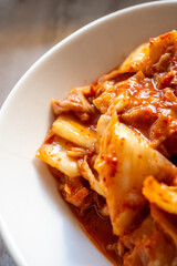 kimchi in fresh white bowl close-up on gray background
