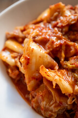 kimchi in fresh white bowl close-up on gray background
