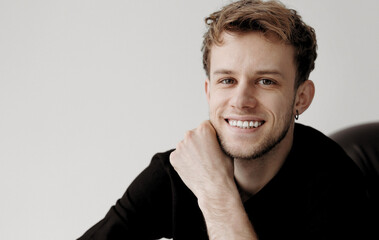 Cheerful young handsome hipster tattooed man 20-25 years in casual clothes smiles with teeth...