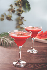 Watermelon refreshing summer frozen cocktail smoothie with watermelon slices and pieces on the background