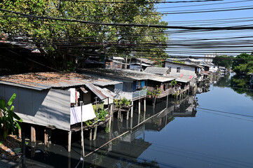 BANGKOK, THAILAND - February 23, 2024: The Old Wooden House on both sides of the sewage canal with blue sky background in Bangkok, Thailand.