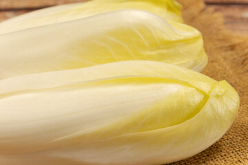 plusieurs endives crues, en gros plan, sur une table	