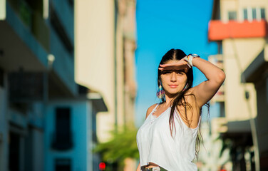 joven mujer al aire en la ciudad en verano cubriendo su rostro del sol 