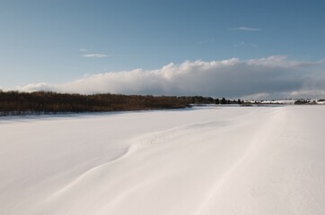 Fototapeta na wymiar snow-covered river in spring, blue sky, sunny evening