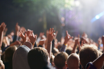 Hands, people and crowd at music festival with dancing for rock party at concert with stage lights, nightclub or dj. Group, entertainment and holiday techno in summer for new years, adventure or rave - obrazy, fototapety, plakaty